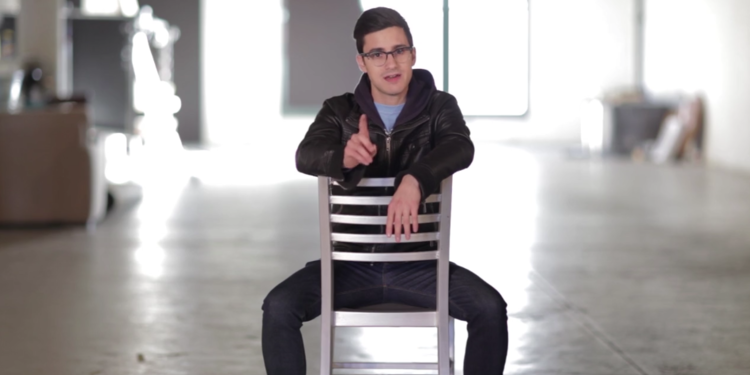 Man sitting backwards on a chair in a warehouse