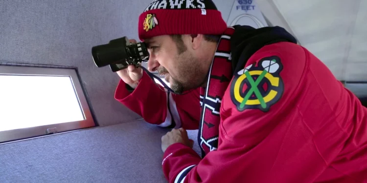 Blackhawks hockey fan with binoculars looking out of the windows at the top of the Gateway Arch