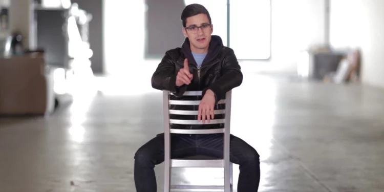 Man sitting backwards on a chair in an empty warehouse